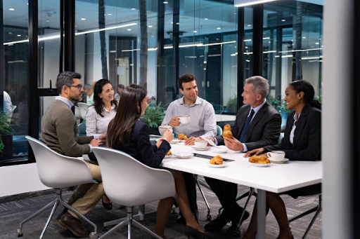 Business professionals discuss RAK Free Zone license fees over coffee in a modern office setting.